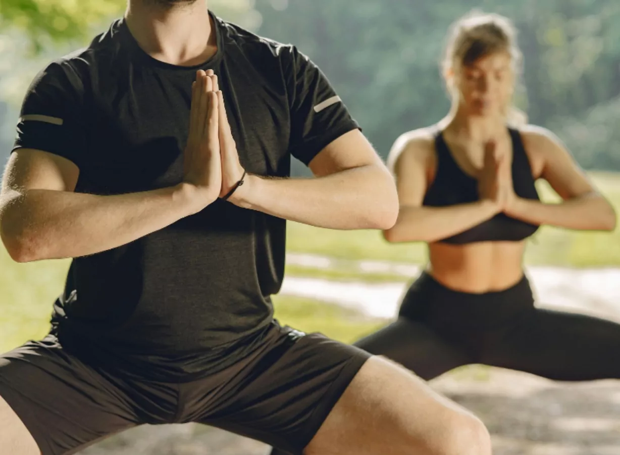 Adults practising outdoor yoga in a peaceful natural setting as part of a wellness retreat, Meadow Bay Villages