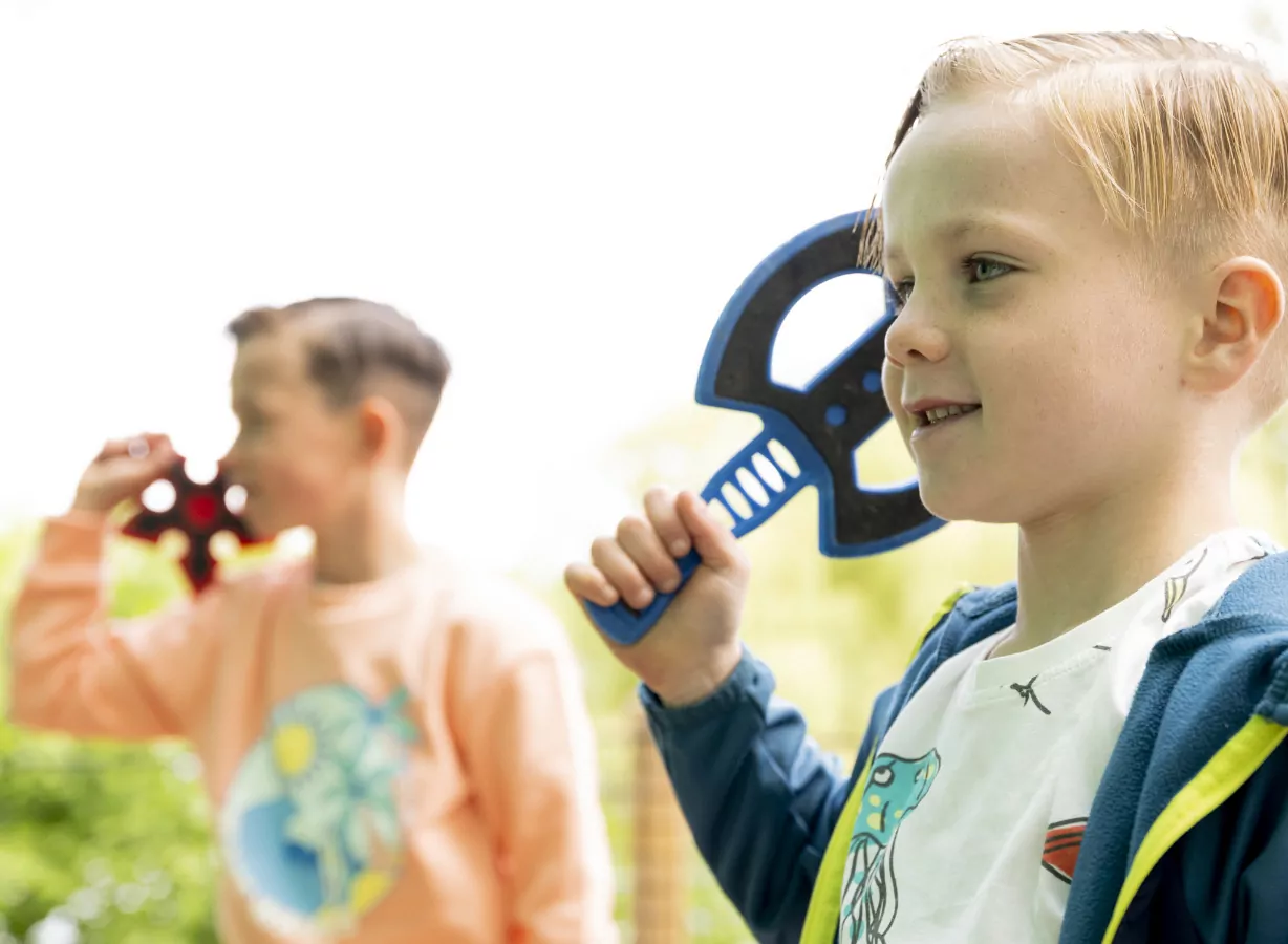 Children enjoying a safe axe throwing activity game during an outdoor adventure session, Meadow Bay Villages.