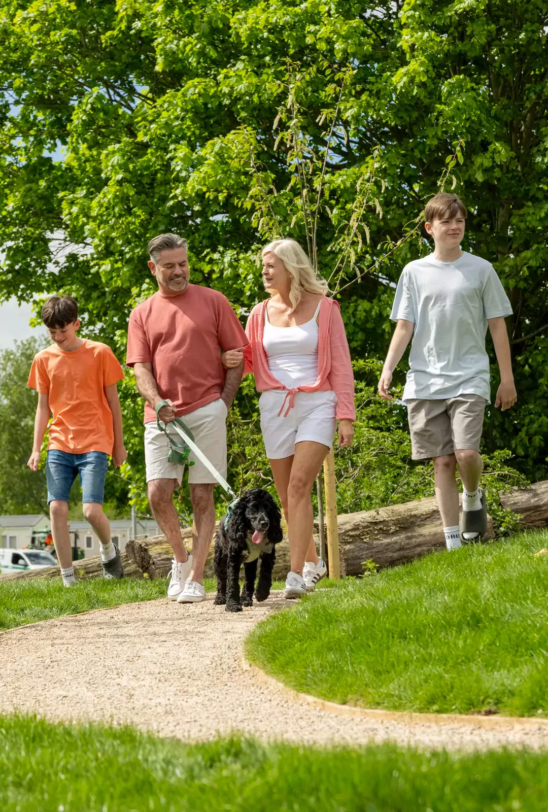 Family enjoying a scenic walk with their dog through the park at Billing Aquadrome