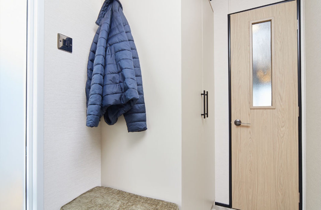 Practical caravan entrance with coat hooks and built-in storage at Meadow Bay Villages