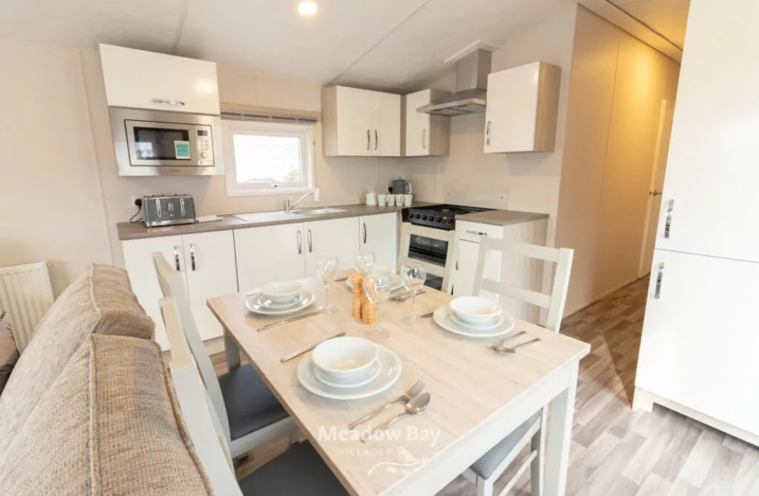 Modern holiday home kitchen with fully equipped dining area at Meadow Bay Villages