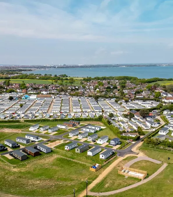 Aerial view of Hayling Island holiday park with holiday homes, open green spaces and surrounding countryside