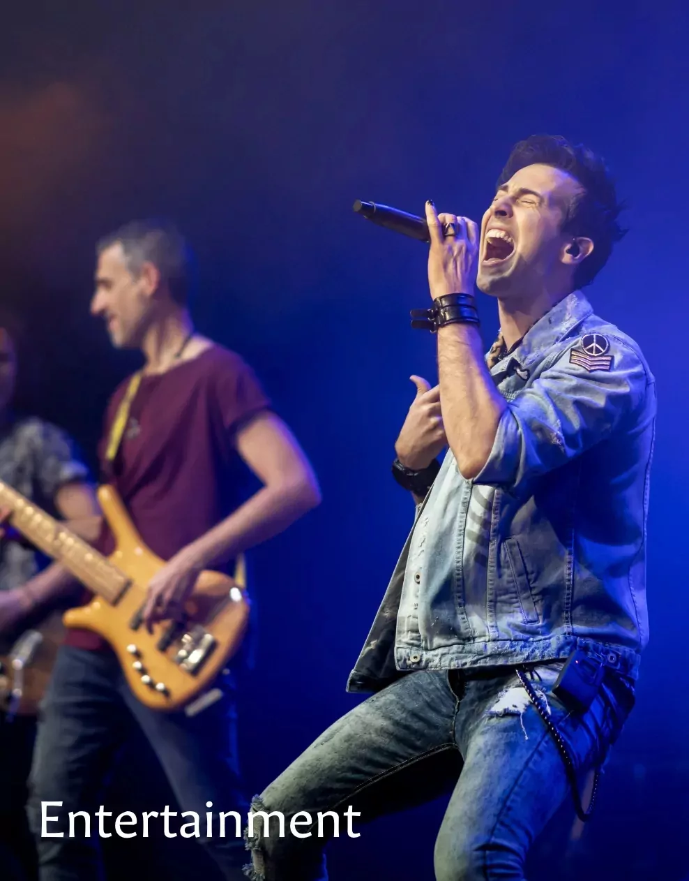 passionate male singer performing on stage with a live band at Meadow Bay Villages.