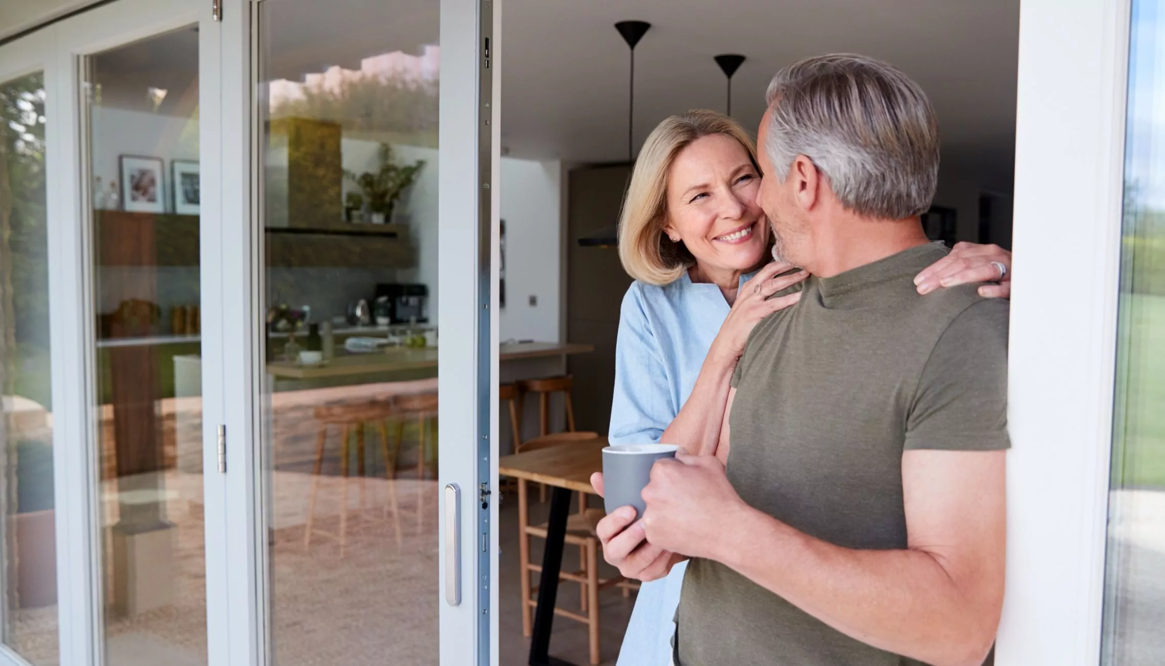 Couple relaxing together with drinks inside a modern holiday home, enjoying peaceful moments at Meadow Bay Villages